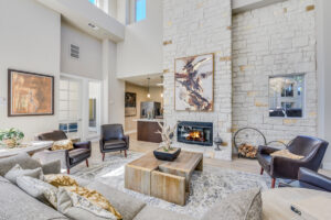 Elegant clubhouse lounge featuring a fireplace, high ceilings, and a contemporary interior design with ample natural light.