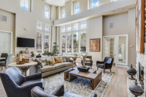 Spacious clubhouse lounge with high ceilings, large windows, comfortable seating, and contemporary decor at Acclaim at South Congress.