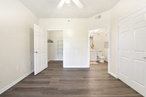 Bedroom with an open layout, ceiling fan, and direct access to a walk-in closet and bathroom.